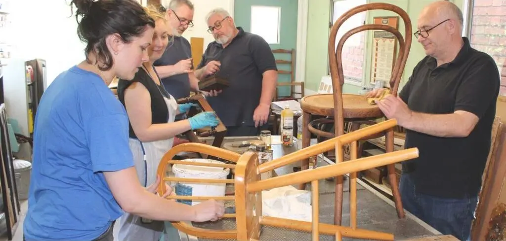 Beneficiaries working to restore antique funiture in the Millrace workshop